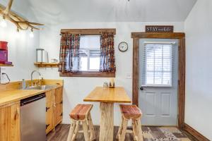 een keuken met een houten tafel en 2 krukken bij Glenvil Cabin with Gas Grill Steps to Dock and Pond! 