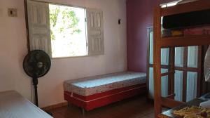 ein Schlafzimmer mit einem Fensterplatz neben einem Etagenbett in der Unterkunft Hospedagem da Lua no Sobrado Delas in Alter do Chao