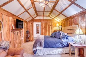 een slaapkamer met een bed in een kamer met houten wanden bij Glenvil Cabin with Gas Grill Steps to Dock and Pond! 