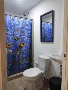 uma casa de banho com um WC e uma cortina de chuveiro em La Gran Mansión en el corazón de Pereira em Pereira