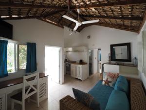 ein Wohnzimmer mit einem blauen Sofa und einer Küche in der Unterkunft Bayahibe Guest House Hotel in Bayahibe