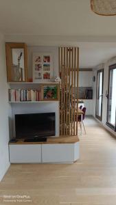 a living room with a flat screen tv in a room at Appartement avec terrasse in Saint-Denis