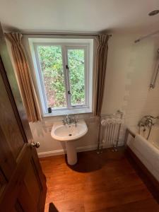 a bathroom with a sink and a window at Torside Holiday Cottage in Castleton