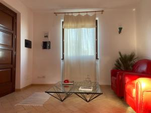 un soggiorno con divano rosso e tavolo in vetro di Casa Calma a Quarrata