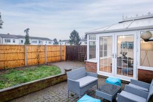 a patio with chairs and a glass house at 3 Bedroom Delight, free parking in Milton Keynes