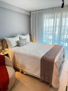 um quarto com uma cama grande e uma janela grande em Apartamento em Maceió - RN Studio 805 em Maceió