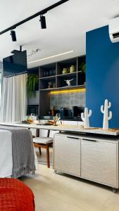 uma grande cozinha com uma parede azul e uma mesa em Apartamento em Maceió - RN Studio 805 em Maceió