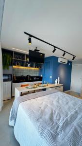 um quarto com uma cama grande e uma parede azul em Apartamento em Maceió - RN Studio 805 em Maceió