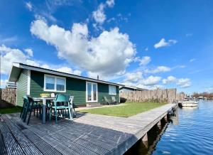 une maison sur un quai avec une table et des chaises dans l'établissement NEW - The Surf Shack - on a lake near Amsterdam!, à Vinkeveen
