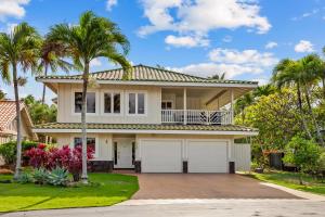 a house with two garage doors and palm trees at Poipu Kai 5 Bed 3 Bath Home- Alekona Kauai in Koloa