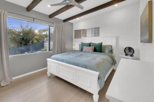a white bedroom with a bed and a window at New! Luxury 5BR, W/Arcade, Sauna, Views, Fire Pit! in San Diego