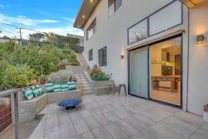 a patio of a home with a large glass door at New! Luxury 5BR, W/Arcade, Sauna, Views, Fire Pit! in San Diego