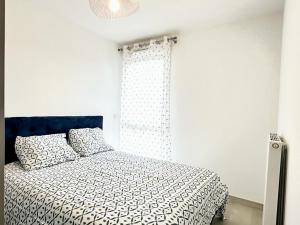 a bedroom with a bed with a black and white comforter at La Frontalière in Ambilly