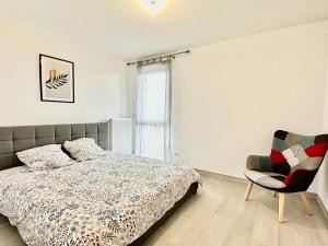 a bedroom with a bed and a chair and a window at La Frontalière in Ambilly