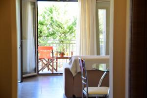 a room with a table and a view of a balcony at Angelos Apartment 1 karavomylos in Karavomylos +9 photos