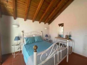 um quarto com uma cama branca e um tecto de madeira em The Captain’s House - 2min walking from the beach em Sesimbra