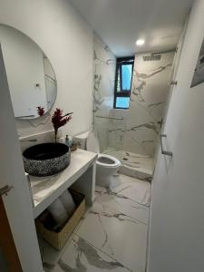 La salle de bains est pourvue d'un lavabo, de toilettes et d'un miroir. dans l'établissement Spondylus Lodge, à Ayampe