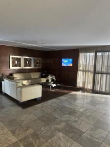 a living room with a couch and a tv at NEO 1.0 in Maceió