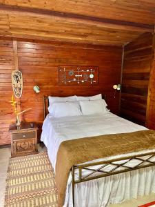 a bedroom with a bed and a wooden wall at Gue Guatok in Salento