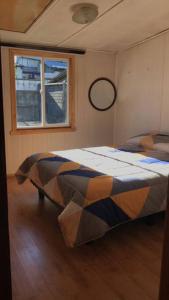 1 dormitorio con 1 cama en una habitación con ventana en Casa de descanso familiar., en Llanquihue