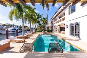 uma piscina com cadeiras e uma casa em Tropical Waterfront 7 Bedroom House in Seven Isles em Fort Lauderdale