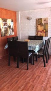 un comedor con mesa, sillas y una pintura en Casa de descanso familiar., en Llanquihue