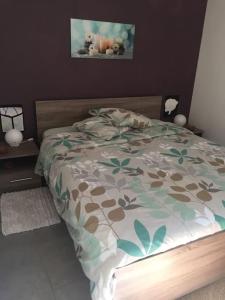 een slaapkamer met een bed met een bloemrijk dekbed bij Le Chapitre, au calme de Senlis in Senlis