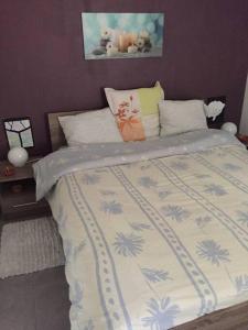 a bedroom with a large bed with a purple wall at Le Chapitre, au calme de Senlis in Senlis