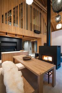 - un salon avec une table en bois et une cheminée dans l'établissement Aparthouse Lubno, à Frýdlant nad Ostravicí