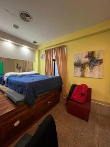 um quarto com uma cama e uma cadeira em Aparta Hotel em Buenos Aires
