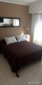 1 dormitorio con 1 cama grande y 2 almohadas en ALQUILO CASA EN NECOCHEA en Necochea