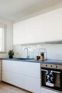 een keuken met witte kasten en een wastafel bij Kaunis moderni tilava asunto in Rauma