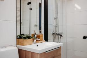 a bathroom with a white sink and a shower at Kaunis moderni tilava asunto in Rauma