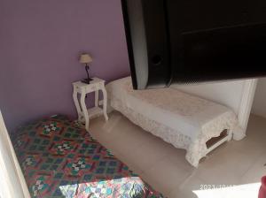 Dormitorio pequeño con cama y mesa con lámpara en ALQUILO CASA EN NECOCHEA en Necochea