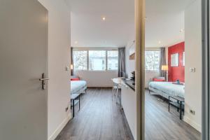 ヴィルールバンヌにあるStudio proche tête d'Or 2 personnes Villeurbanneのベッド2台と鏡が備わるホテルルームです。