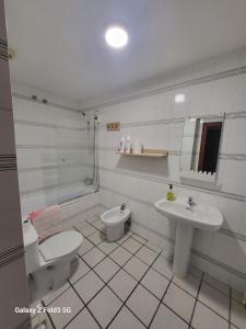 bagno bianco con servizi igienici e lavandino di Habitacion muy céntrica. a Granada