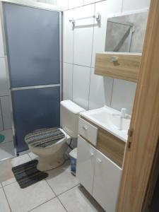 y baño con aseo, lavabo y ducha. en Casa Mendes en Gramado