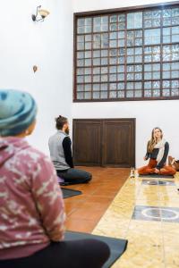 un grupo de personas sentadas en el suelo en una habitación en Vihara - Spa, Yoga, Wellness & Events en Antigua Guatemala