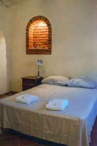 a bedroom with a bed with two towels on it at Vihara - Spa, Yoga, Wellness & Events in Antigua Guatemala