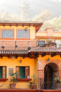a yellow house with a balcony at Vihara - Spa, Yoga, Wellness & Events in Antigua Guatemala