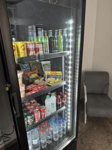 a refrigerator filled with lots of drinks and a chair at Lize Prime Hotel in Campinas