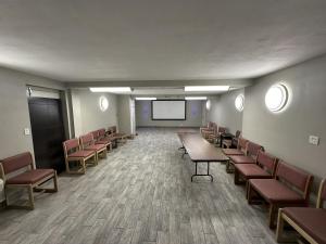 een conferentieruimte met tafels en stoelen en een scherm bij Extend-A-Suites Albuquerque West in Albuquerque