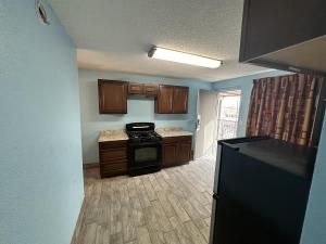 een keuken met houten kasten en een zwarte kachel bij Extend-A-Suites Albuquerque West in Albuquerque