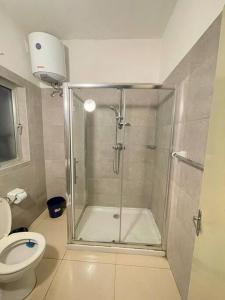 a bathroom with a shower and a toilet at SunnyGem Retreat in St Paul's Bay