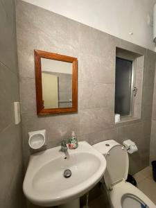 a bathroom with a sink and a toilet and a mirror at SunnyGem Retreat in St Paul's Bay