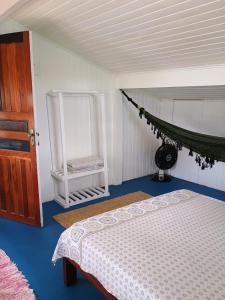a bedroom with a bed and a chair at Hostel 7 praias in Ubatuba