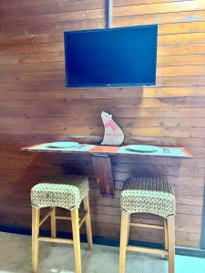 a desk with two chairs and a tv on a wall at Gue Guatok in Salento +15 photos