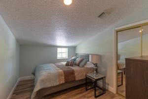 a bedroom with a bed and a lamp on a table at Lake Side Loft Appt in Loxahatchee