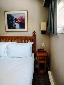 um quarto com uma cama e uma mesa de cabeceira com um relógio em Cozy apartment in the heart of Panorama em Panorama