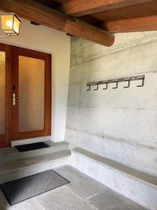 drzwi wejściowe budynku z kamienną ścianą w obiekcie Casa Campanula - No 1 Ferienhaus in Laax w mieście Laax